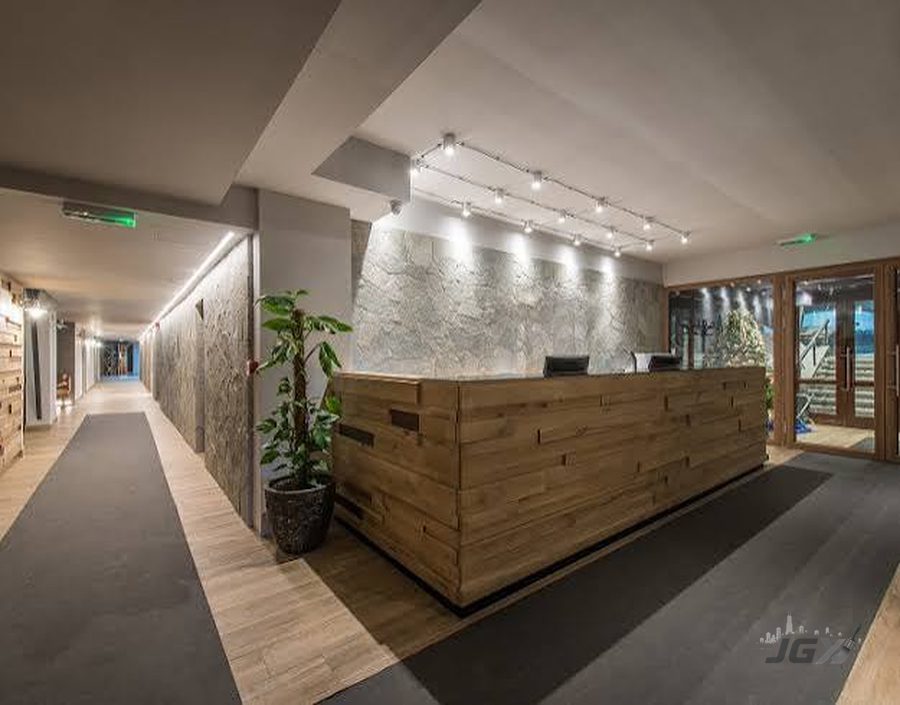 Modern lobby and hallway common area with stone accent wall and wood reception desk