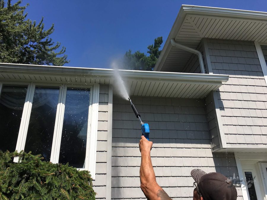 Pressure washing siding and gutters before painting