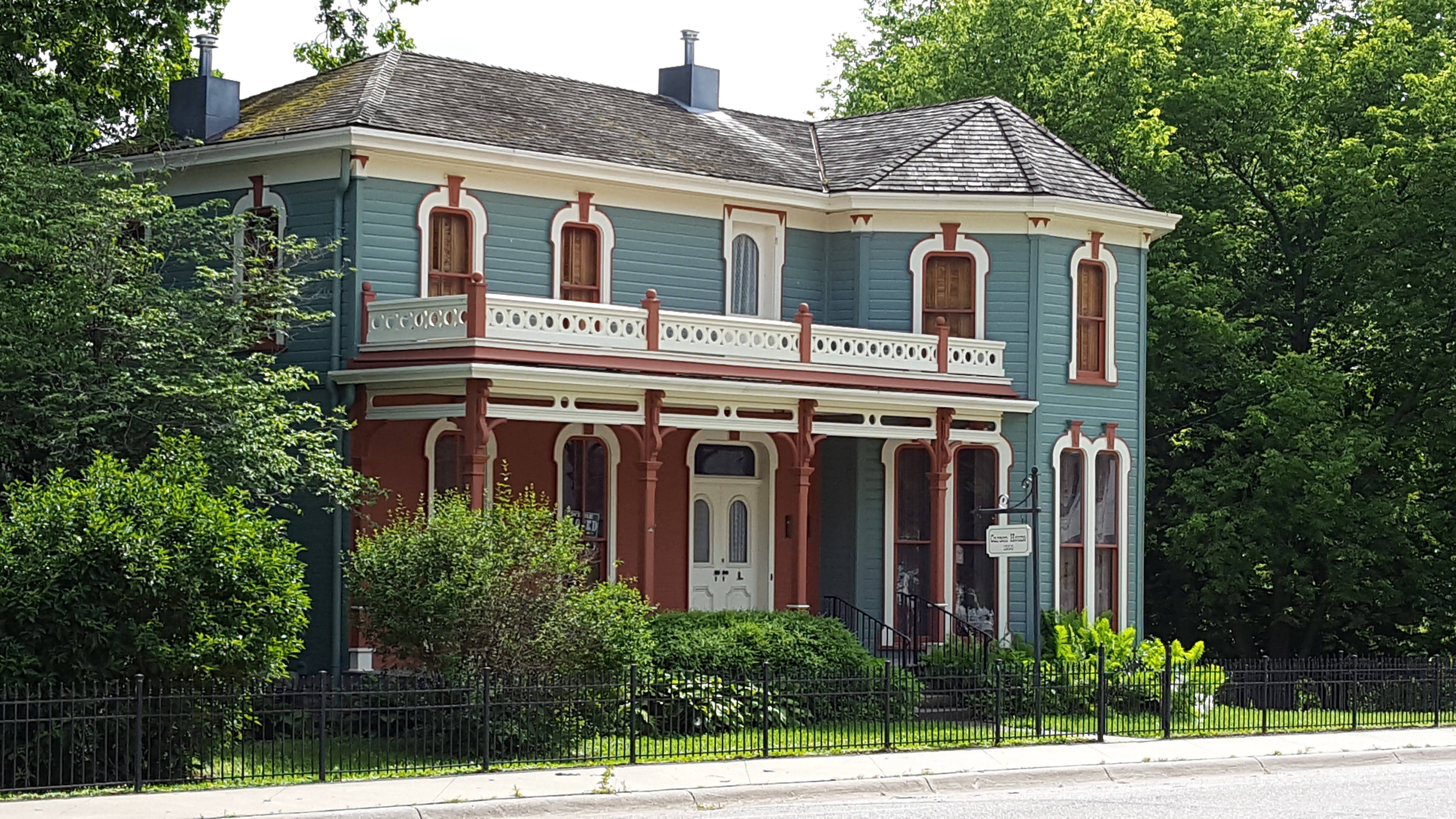 Two-story Victorian house in Evanston, IL with a double-decker porch, blue-gray siding, and rust-red trim.