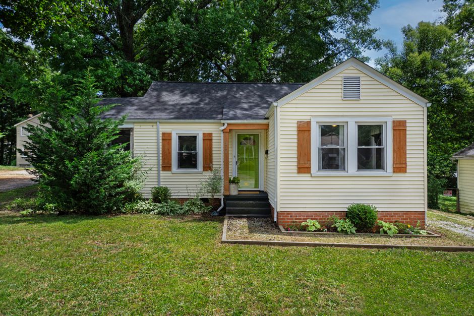 Front view of a quaint single-story house with garden landscaping.