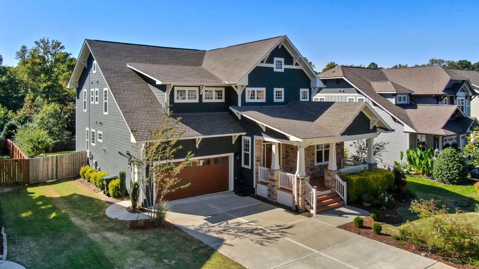 A beautiful Craftsman-style house with a spacious porch and manicured lawn.