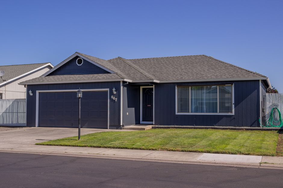Charming suburban house with driveway, garage, and well-maintained lawn.
