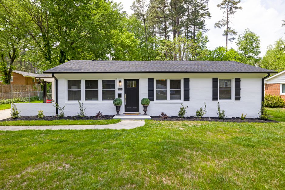 Front view of a charming suburban ranch house with modern landscaping and fresh paint, capturing the essence of cozy living.